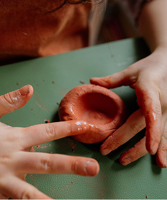 Ребенок лепит изделие из глины